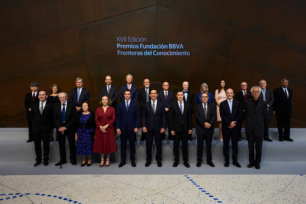 A group of 20 researchers and creatives stand for a portrait; behind them is the Spanish text "XVII Edición, Premios Fundación BBVA, Fronteras del Conocimiento"