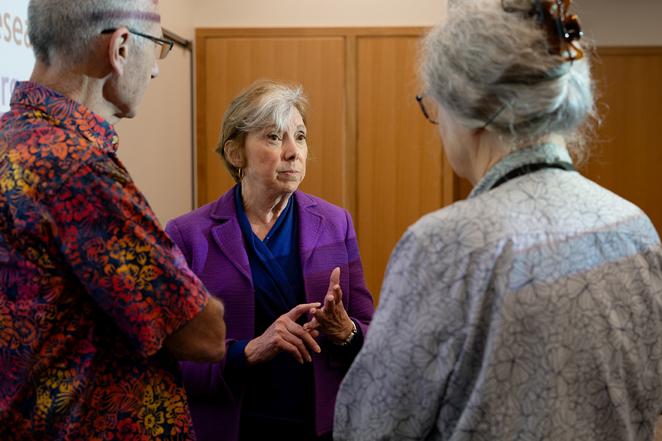 Diana Zuckerman speaks to two people in a lecture hall.