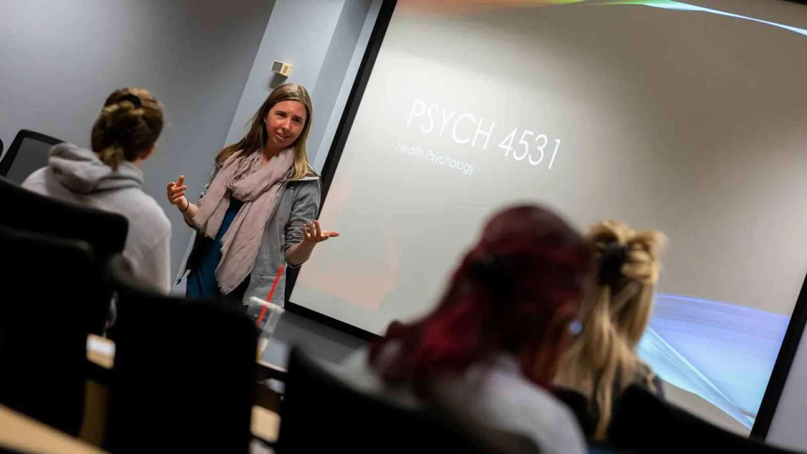 Psychology Professor speaking in front of a course