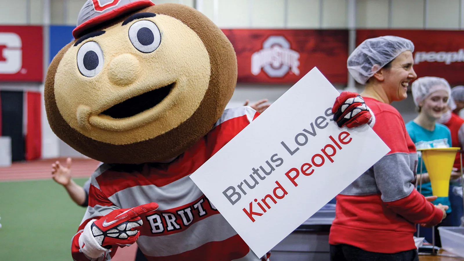 Brutus Buckeye with sign that reads "Brutus Loves Kind People"