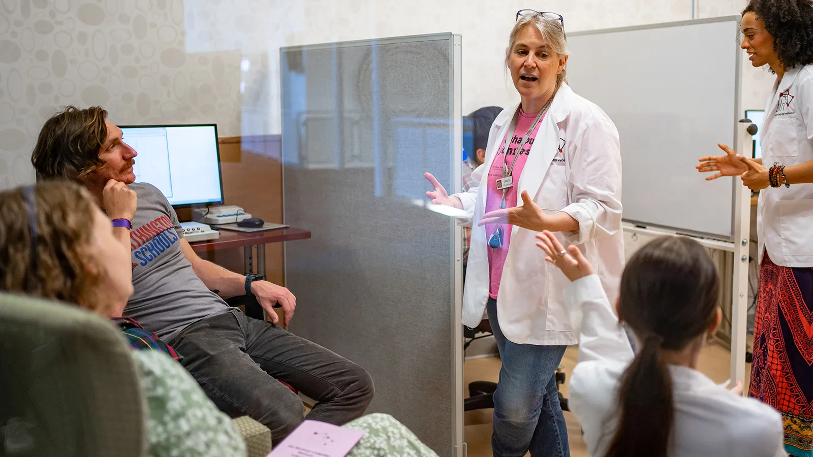 Laura Wagner speaks to a group of people inside the COSI language pod