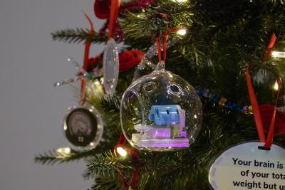 A miniature Lego fMRI scanner encased in glass and hanging on a Christmas tree