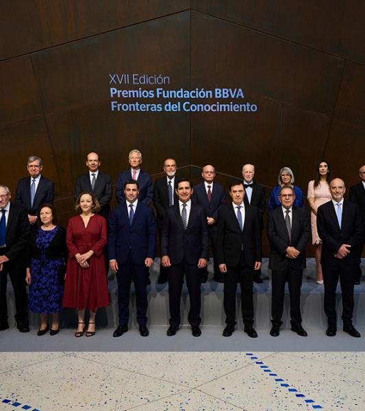 A group of 20 researchers and creatives stand for a portrait; behind them is the Spanish text "XVII Edición, Premios Fundación BBVA, Fronteras del Conocimiento"