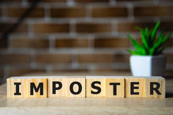 Wooden blocks with letters on them that spell out imposter