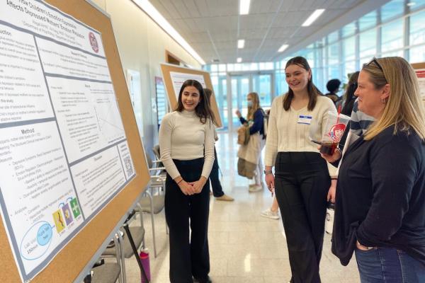 Student presents her research poster to others