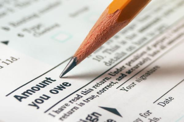 Close up of a pencil filling in the "Amount You Owe" section of a tax form.