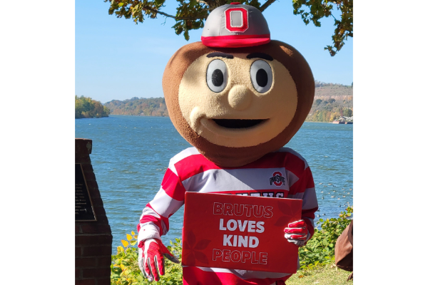 Brutus Holding a "Brutus loves kind people" sign