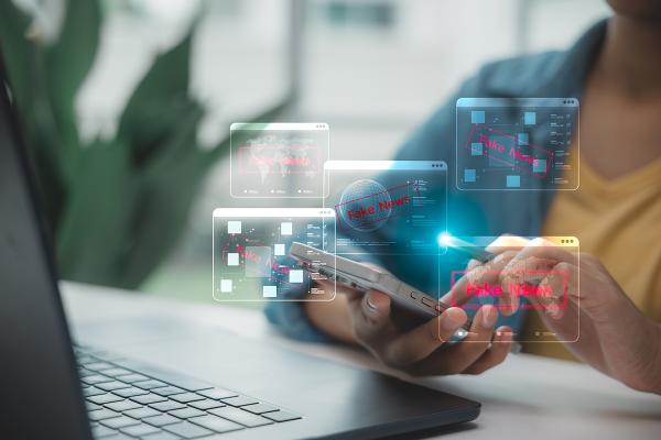 Windows identifying "fake news" pop up as a person scrolls on their smartphone.