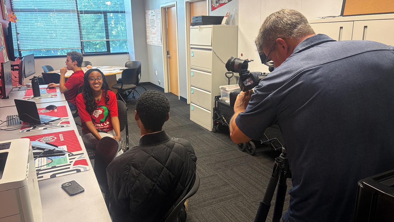 A TV cameraman records Meseret Alemu as she sits and speaks to her mentor